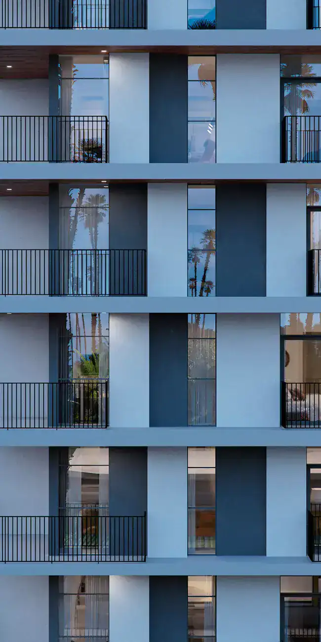 Modern residential apartment building façade with balconies and large windows.