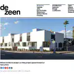 Modern white stucco co-living buildings with flat roofs and minimalist design, featuring large windows and small landscaped front yard.